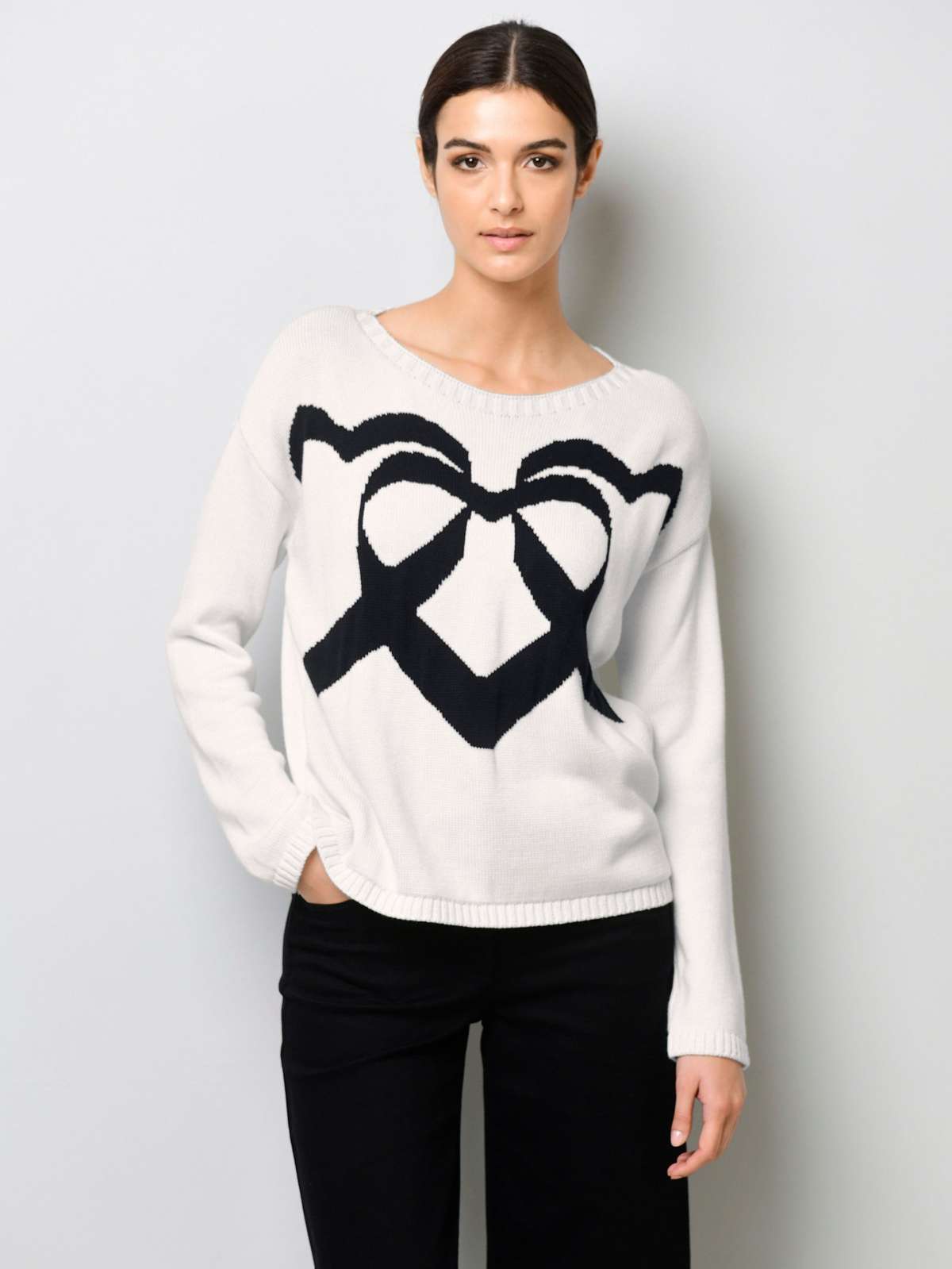 Вязаный пуловер с вязаным сердечком спереди.